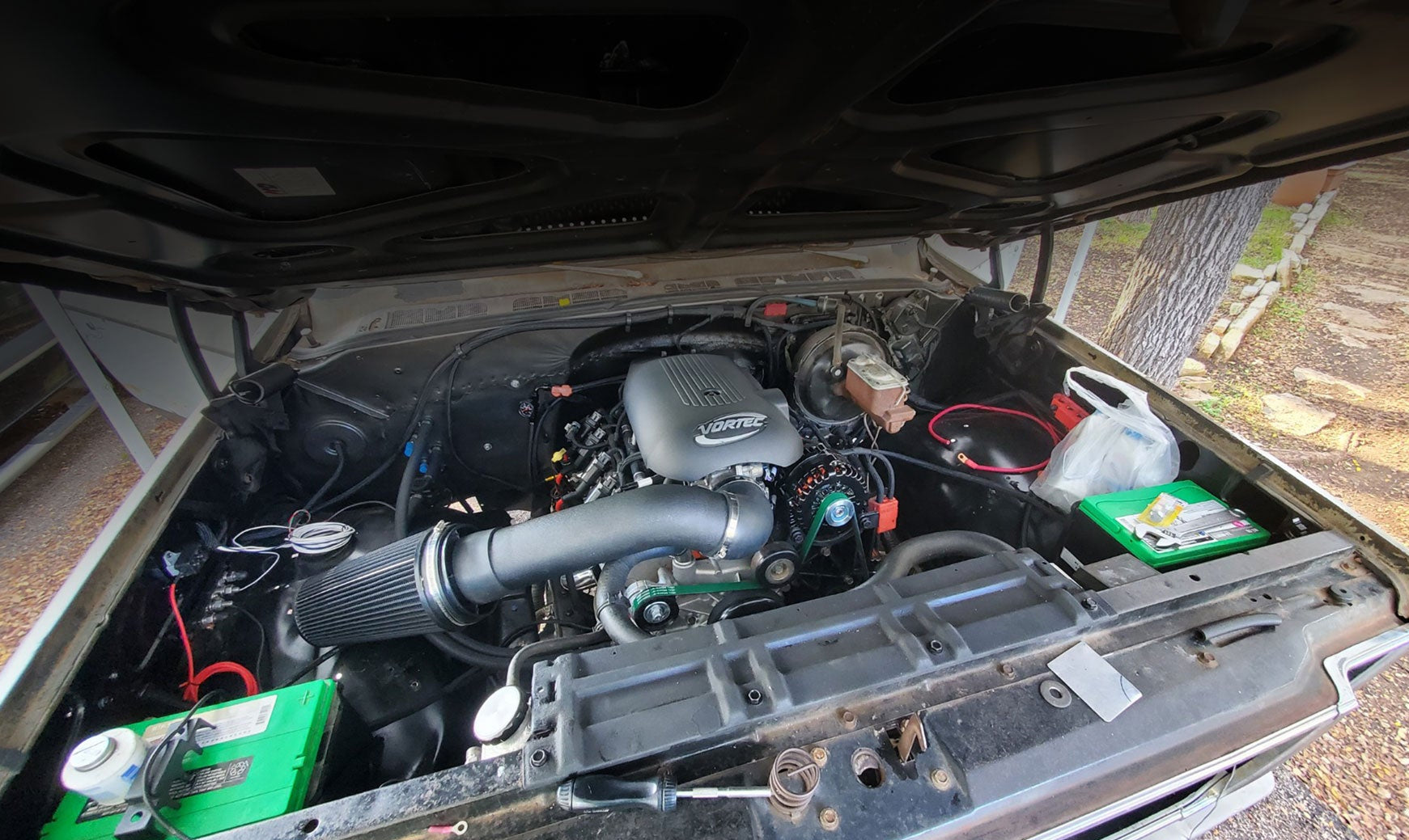 Engine compartment of a vehicle with visible components and wiring.